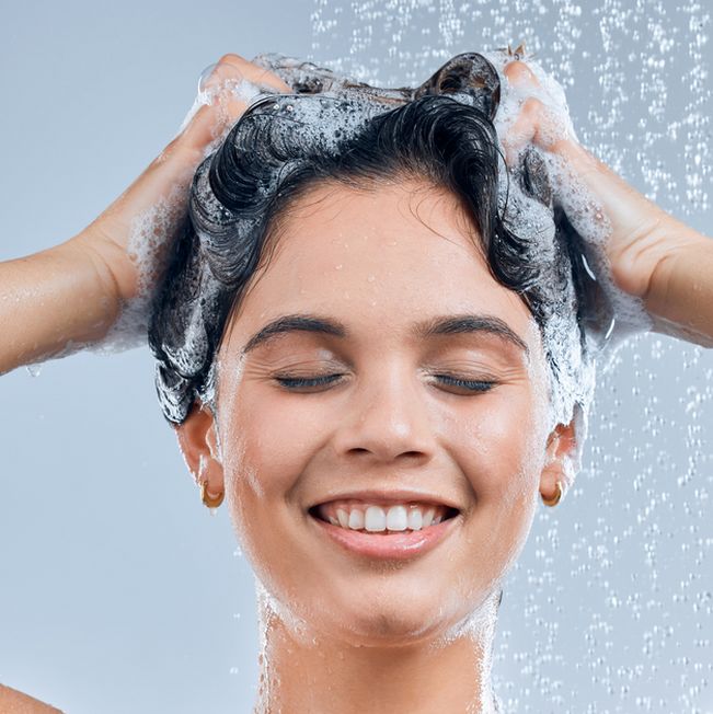Mujer usando champú para dermatitis seborreica en el cabello Mujer usando champú para dermatitis seborreica en el cabello